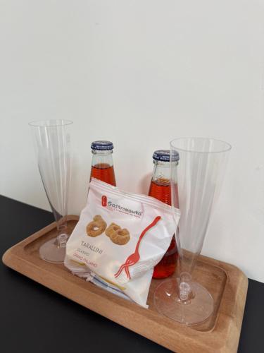 a tray with two bottles and two wine glasses at A tre passi dal mare in Agropoli