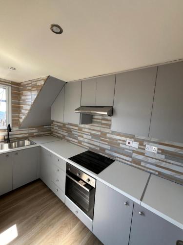 a kitchen with white cabinets and a stove top oven at Odou Off-grid in Odhou