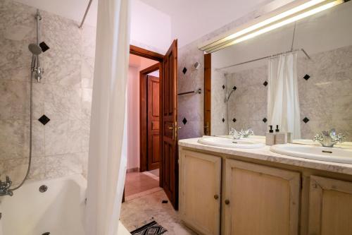 a bathroom with two sinks and a tub and a shower at Villa Panagiota, Pefkos in Pefki Rhodes