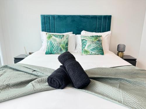 a bed with two black towels on it at 3 Bedroom Penthouse In The City Centre Deansgate New Build High Floor in Manchester