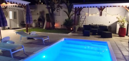 a swimming pool in a backyard at night at Appartements Des Roses in Le Lamentin