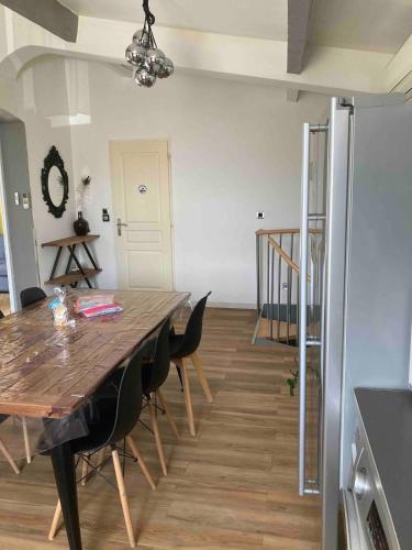 une salle à manger avec une table et des chaises en bois dans l'établissement Maison chaleureuse, à Simiane-Collongue