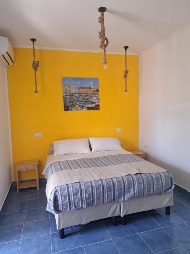 a bedroom with a bed with a yellow wall at B&B Oasi al Mare in Agropoli