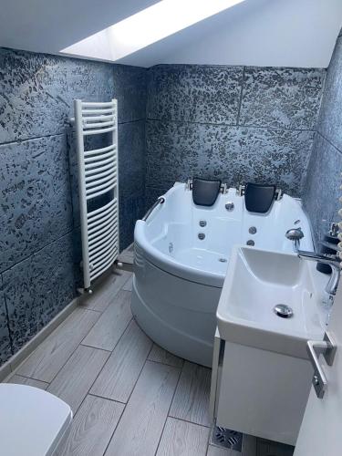 a bathroom with a bath tub and a sink at Vila El Passo in Târgu-Mureş