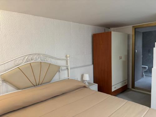 a bedroom with a white bed and a bathroom at B&B IL GIRASOLE in Maddaloni