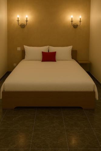 une chambre avec un lit avec un oreiller rouge dessus dans l'établissement Logement cosy avec piscine et jacuzzi privé, à Poussan