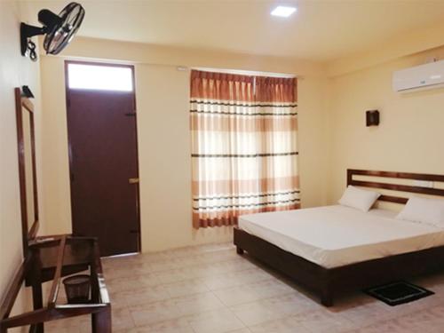 a bedroom with a bed and a window and a door at Dream Day Leisure Homes in Sigiriya