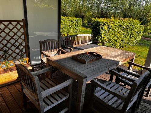 a wooden table and chairs on a deck at Residentie Pelikaan - nice view on the Leie in Deinze