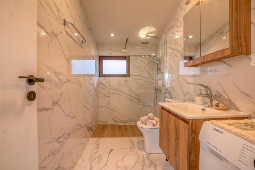 a white bathroom with a sink and a toilet at Angela Home, 5Street, Perivolia in Perivólia