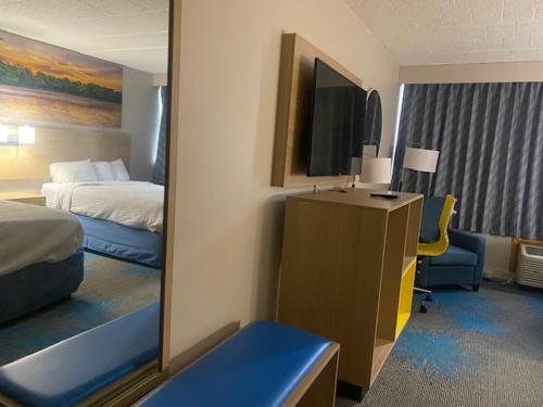 a hotel room with a bedroom with a bed and a mirror at Days Inn by Wyndham Scranton PA in Dickson City