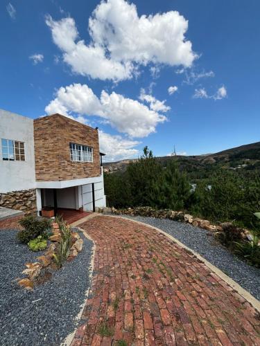 a house with a brick driveway in front of it at The house in the mountains in Tinjacá