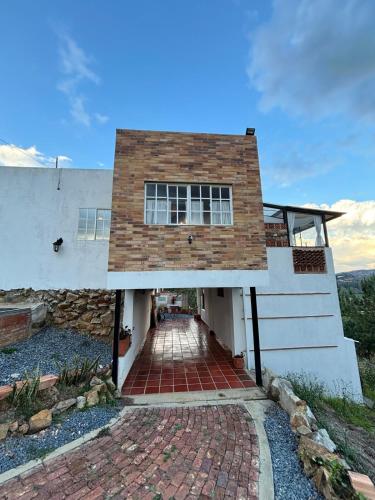 a house with a brick walkway in front of it at The house in the mountains in Tinjacá
