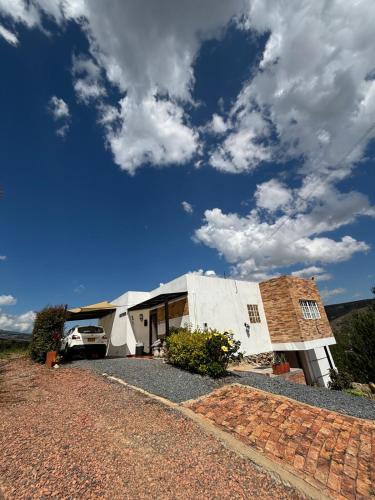 a house with a car parked in front of it at The house in the mountains in Tinjacá