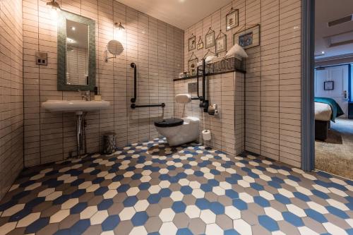 a bathroom with a toilet and a sink at Hand and Spear in Weybridge