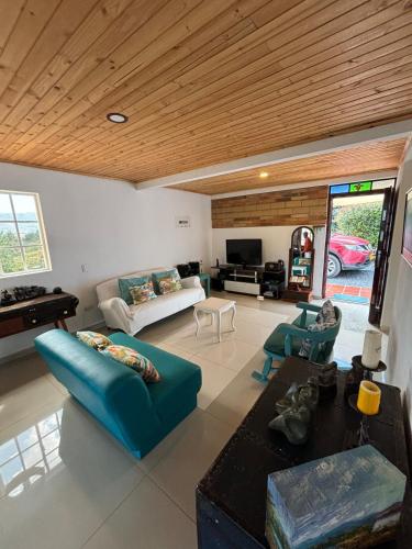 a living room with a blue couch and a table at The house in the mountains in Tinjacá
