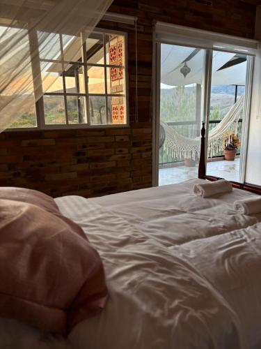 a large white bed in a room with a window at The house in the mountains in Tinjacá