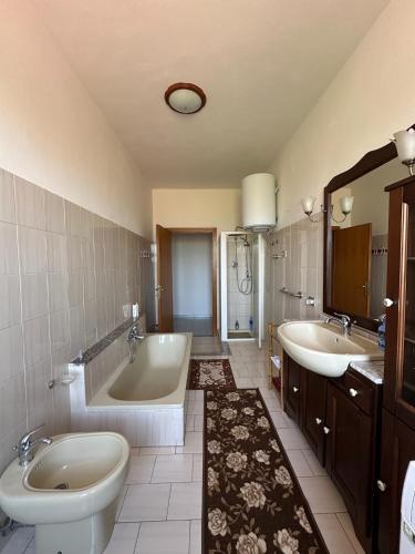a bathroom with two sinks and a tub and a toilet at Sa Domu di Beppe e Nora in San Giovanni Suèrgiu