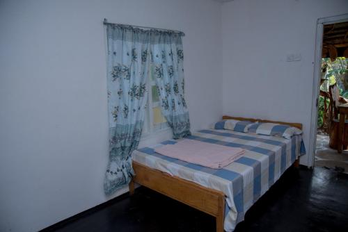 a small bed in a room with a window at Blooming Rose Homestay in Ohiya