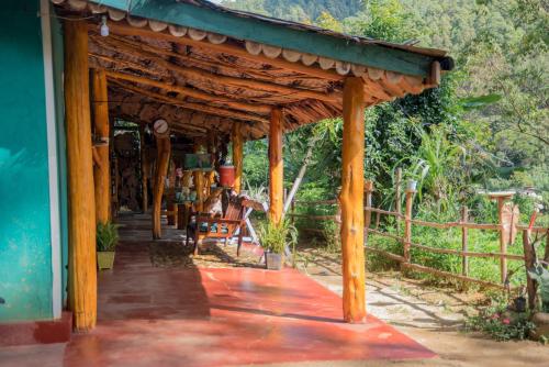 a porch of a house with a wooden roof at Blooming Rose Homestay in Ohiya