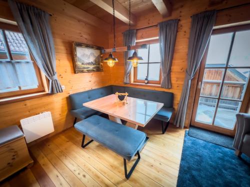 a dining room with a table and chairs and windows at Almhütte Falkert in Patergassen
