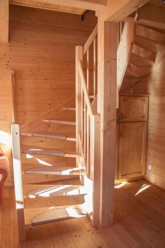 a wooden staircase in a log cabin with a door at Almhütte Falkert in Patergassen