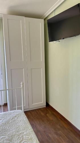 a bedroom with a bed and a closet with a television at El piso del pueblo in Mansilla de las Mulas