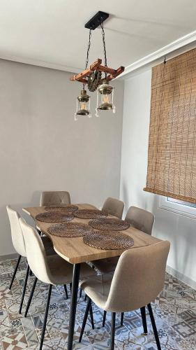a dining room table with chairs and a chandelier at El piso del pueblo in Mansilla de las Mulas