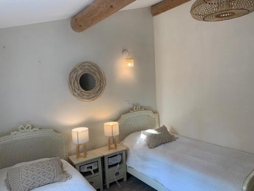 - une chambre avec 2 lits, un miroir et 2 lampes dans l'établissement La Pomme de Pin, à Eygalières