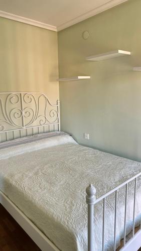 a bedroom with a bed with a white bedspread at El piso del pueblo in Mansilla de las Mulas