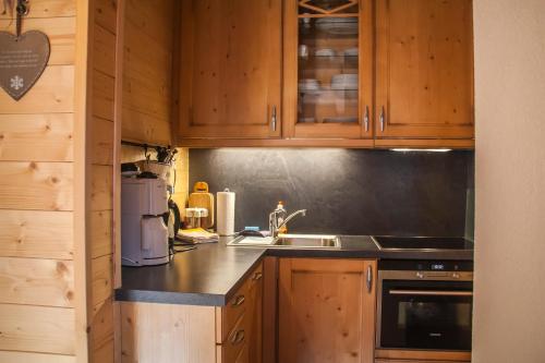 a kitchen with wooden cabinets and a counter top at Almhütte Falkert in Patergassen