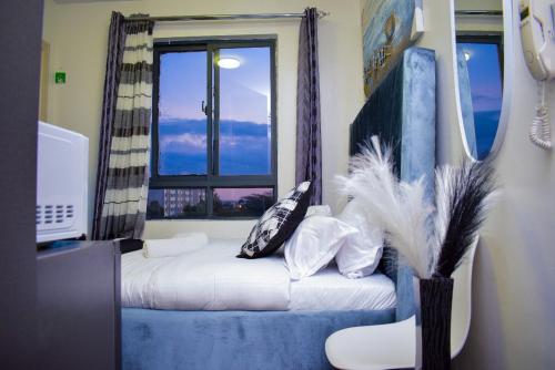Camera con letto, finestra e divano. di Brenda luxury homes a Nairobi