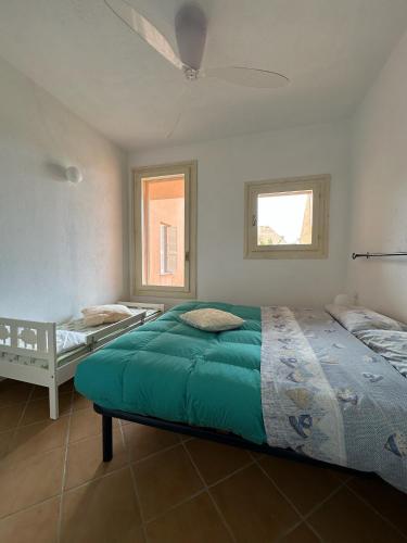 a bedroom with two beds and a ceiling fan at Domus Strazza Porto Quadro in Santa Teresa Gallura