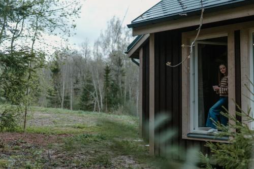 a woman standing in a window of a house at Rītu atpūtas namiņi in Talsi