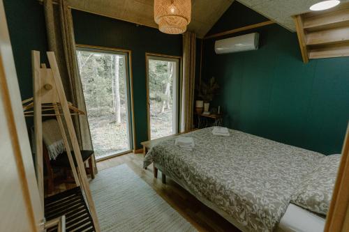 a bedroom with a bed and a large window at Rītu atpūtas namiņi in Talsi