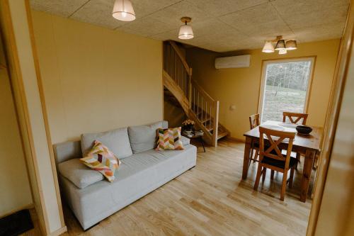 a living room with a couch and a table at Rītu atpūtas namiņi in Talsi