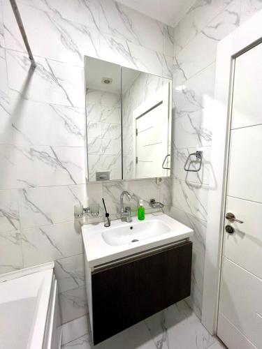 a white bathroom with a sink and a mirror at Istanbul City 6 by Royal Rentals in Stantsiya Kyzyl-Tukumachi