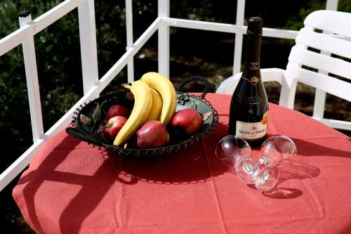 a basket of fruit on a table with a bottle of wine at Kappatos Studios & Apartments in Lassi