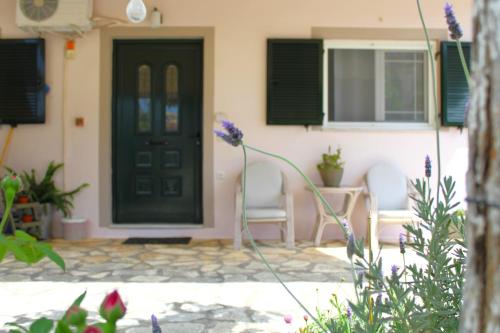 a front door of a house with chairs and flowers at Fissas Rooms in Sivota