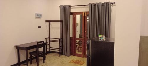 a room with a desk and a table and a door at The Nest in Weligama