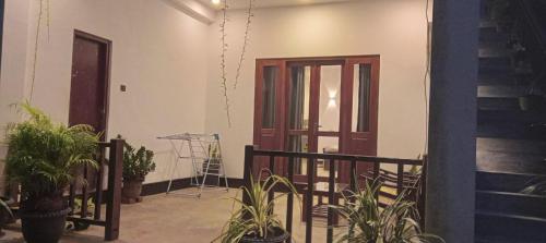 a room with potted plants and a door and stairs at The Nest in Weligama