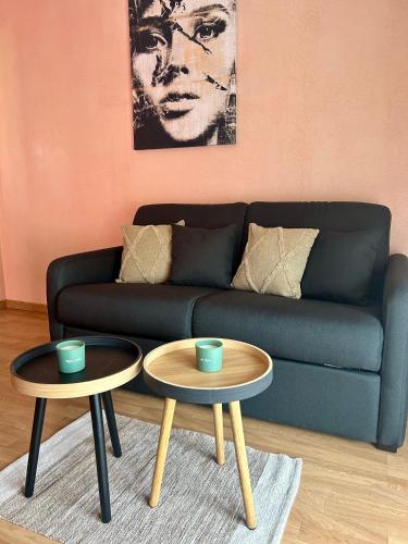 a living room with two tables in front of a couch at MagicLoc in Esbly