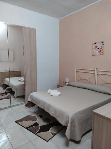 a bedroom with a large bed and a mirror at Casa Natura in Avola