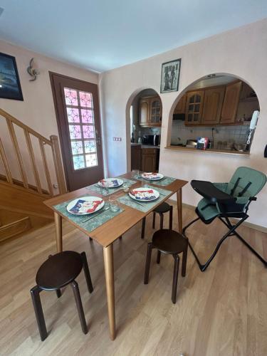 a kitchen with a wooden table and two chairs at MagicLoc in Esbly