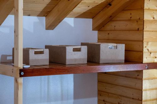 three boxes sitting on a wooden shelf in a room at Adega dos Avós - Casa completa in Alcobaça