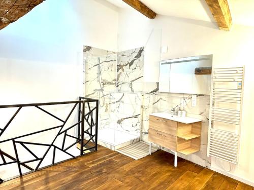 une salle de bain avec un lavabo et un mur en pierre dans l'établissement LE LOFT, 85m2, Hyper-centre, à Mâcon