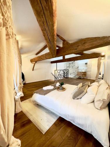 Cette chambre comprend un grand lit blanc et du parquet. dans l'établissement LE LOFT, 85m2, Hyper-centre, à Mâcon