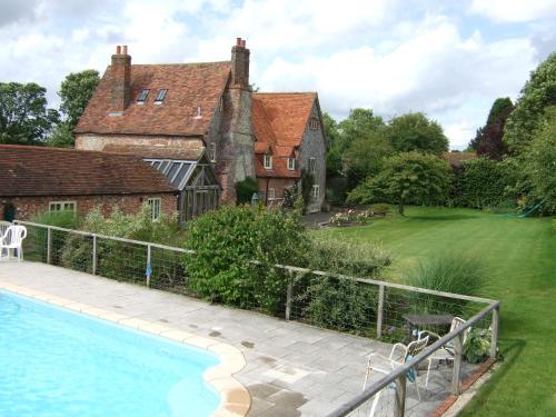 a house with a swimming pool in front of a yard at Westcourt Farm in Shalbourne