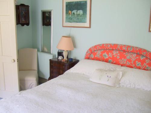 a bedroom with a bed with a red head board at Westcourt Farm in Shalbourne