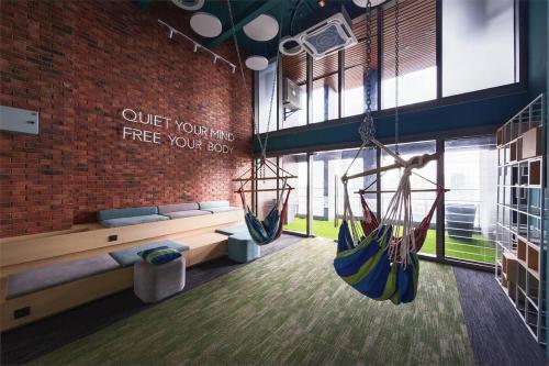 a room with two hammocks hanging from a brick wall at Riveria City KL Sentral by Nest Suite in Kuala Lumpur