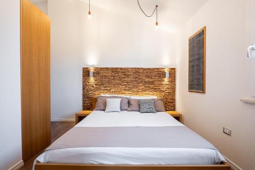 a bedroom with a large bed with a brick wall at Le Terrazze di Bellavista in Su Forti